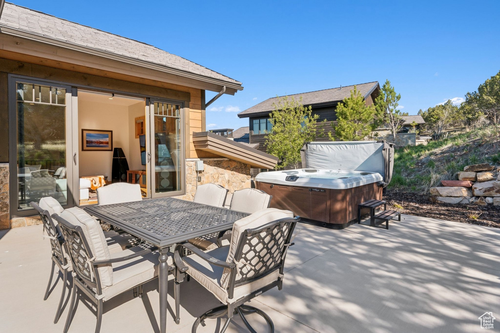 View of patio / terrace with a hot tub and outdoor dining space