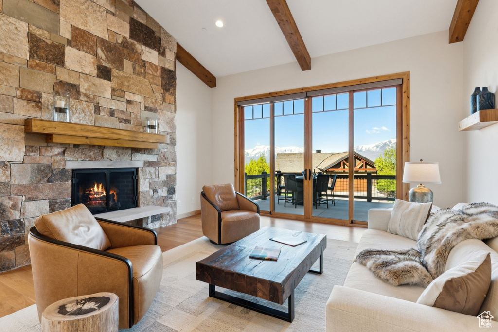 Living room featuring beamed ceiling, wood finished floors, a fireplace, and recessed lighting