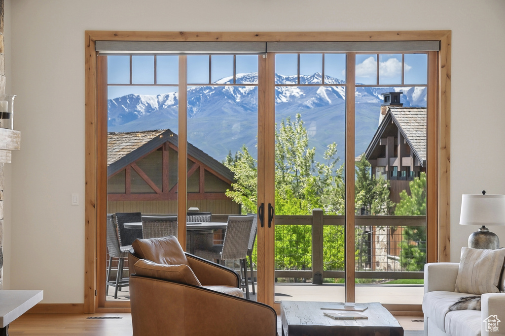 Living area with a mountain view, wood finished floors, and baseboards