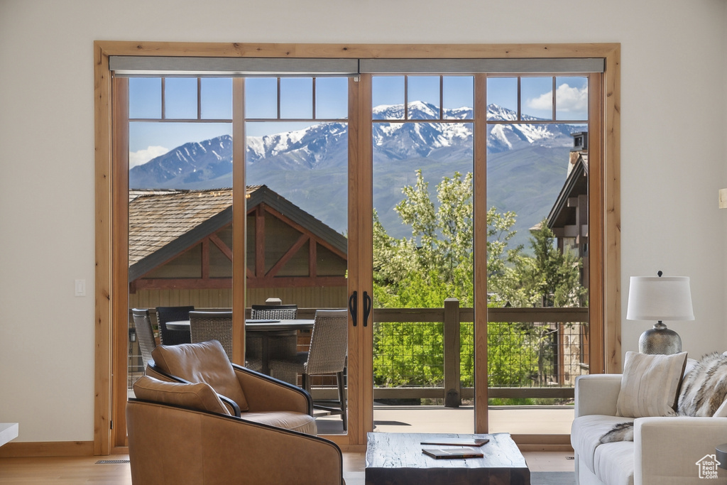 Living room with a mountain view, plenty of natural light, wood finished floors, and baseboards