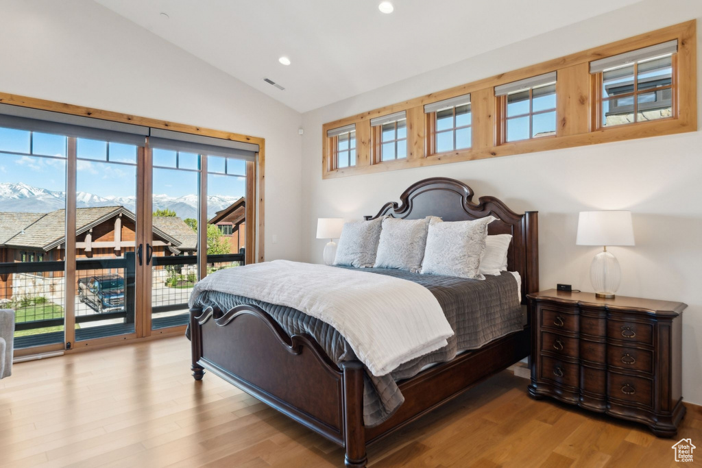 Bedroom with lofted ceiling, access to exterior, wood finished floors, and recessed lighting