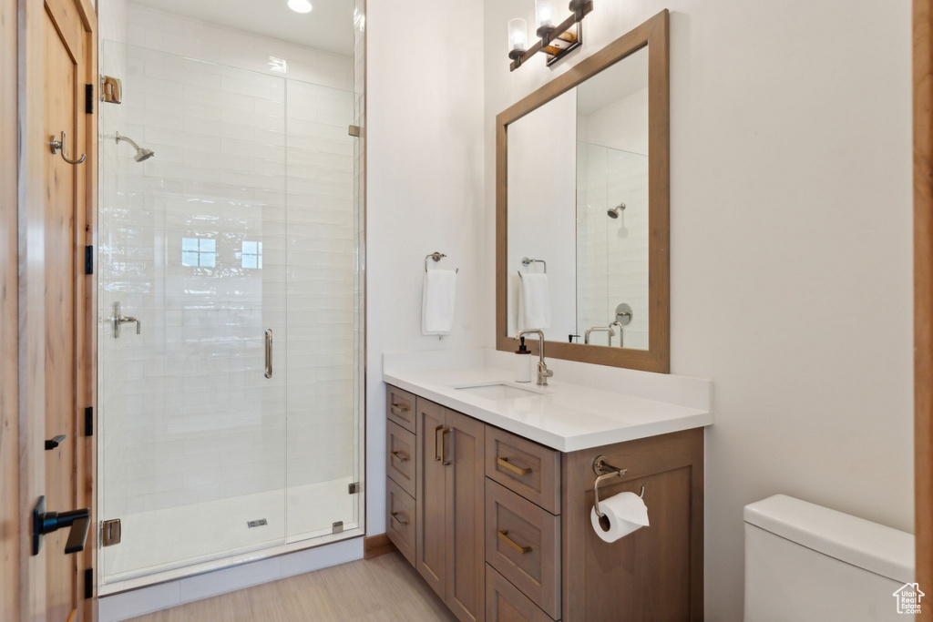 Full bathroom with vanity, toilet, and a shower stall