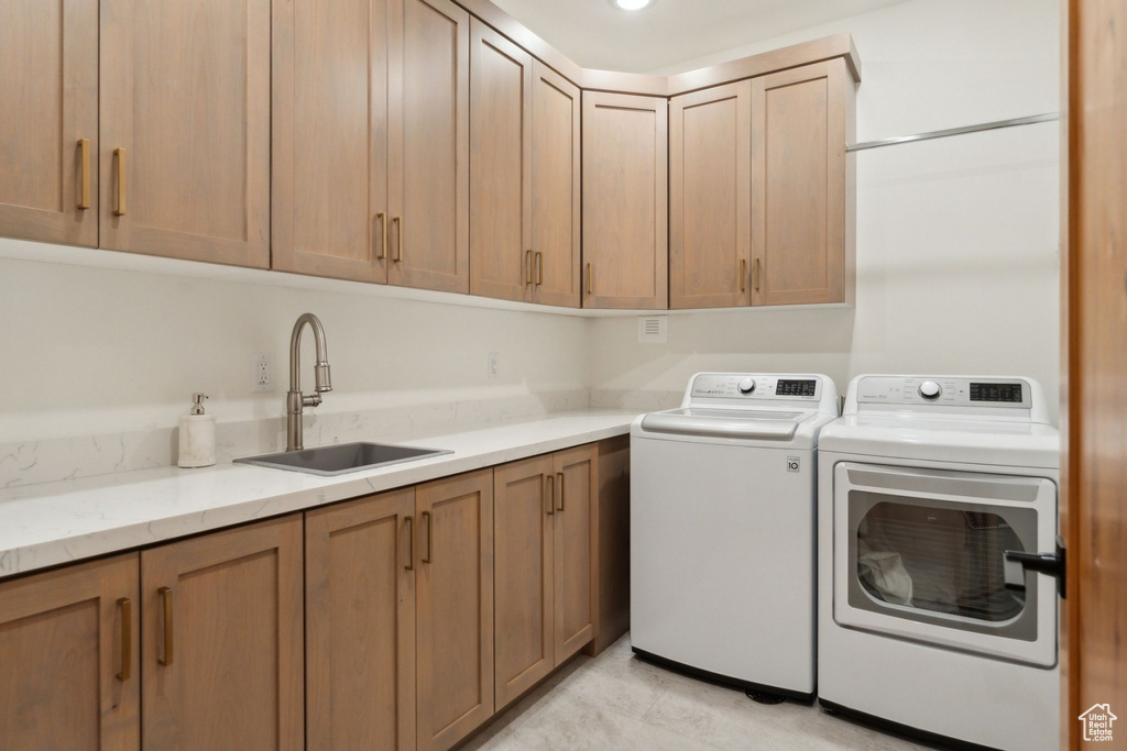 Washroom featuring washing machine and dryer and cabinet space