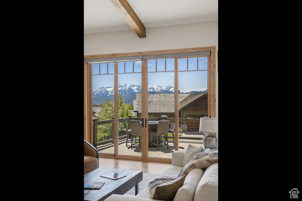 Entryway with beam ceiling, a mountain view, and wood finished floors