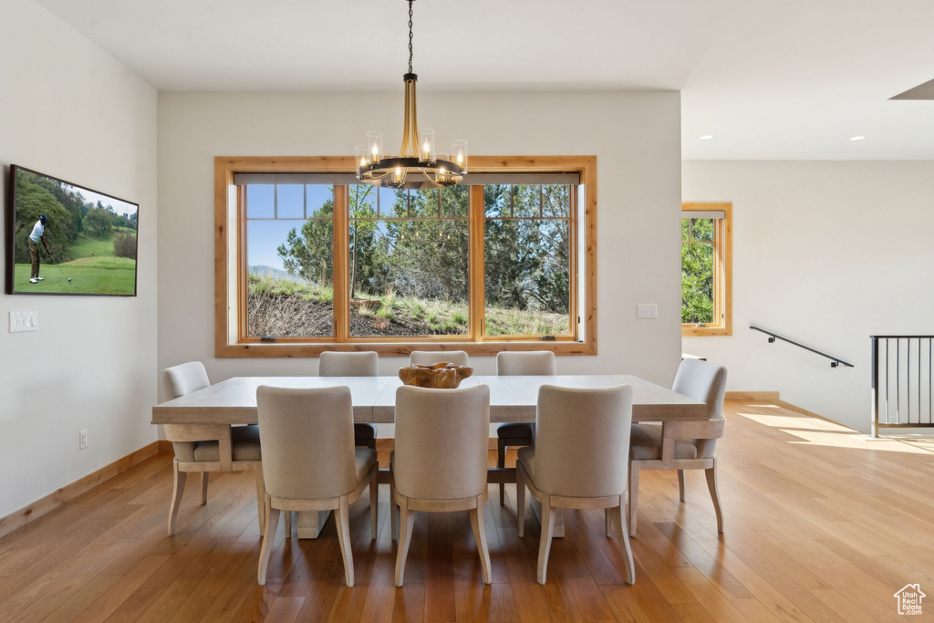 Dining area with a chandelier, plenty of natural light, wood finished floors, and recessed lighting