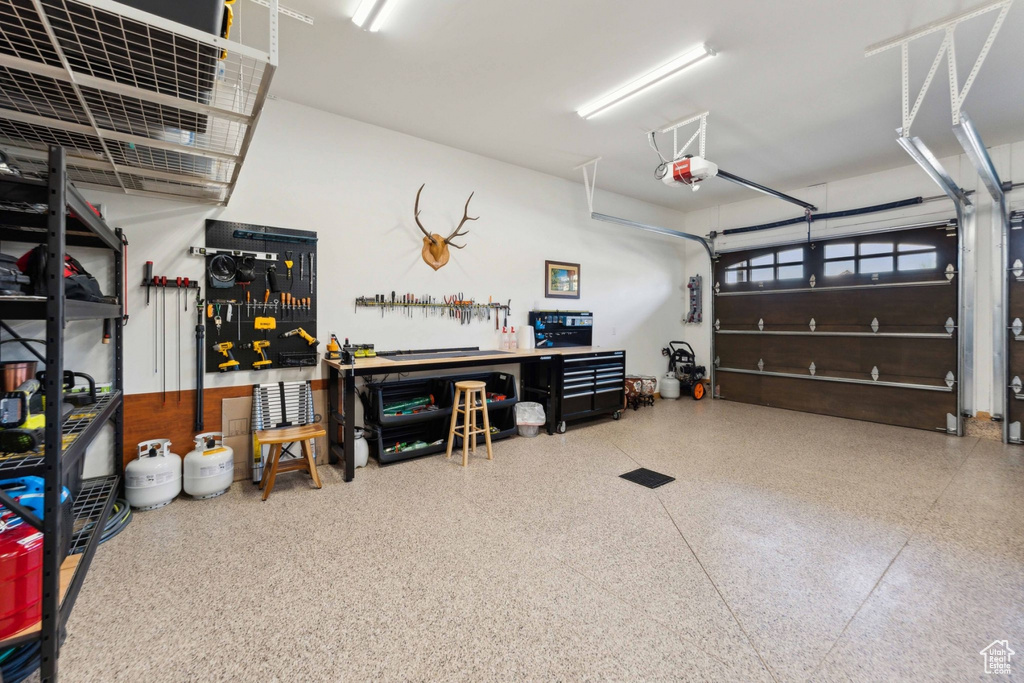 Garage featuring a workshop area and a garage door opener