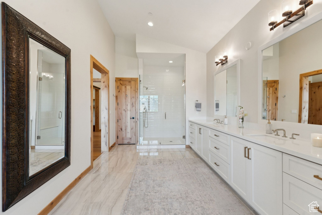 Full bathroom featuring lofted ceiling, double vanity, a stall shower, recessed lighting, and marble finish floors