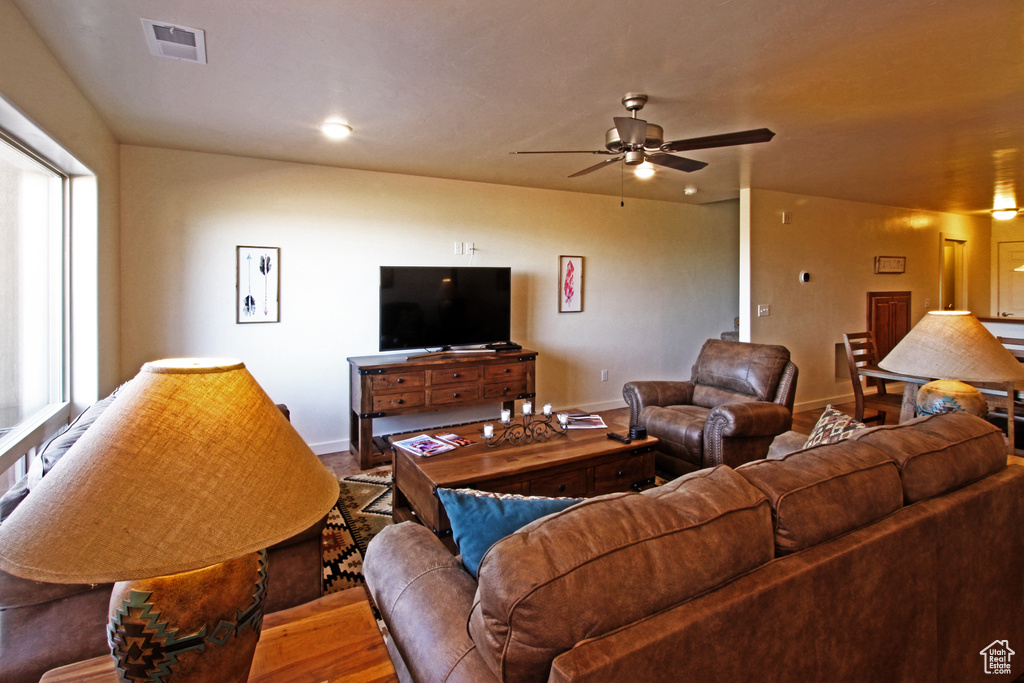 Living area featuring a ceiling fan, wood finished floors, baseboards, and recessed lighting