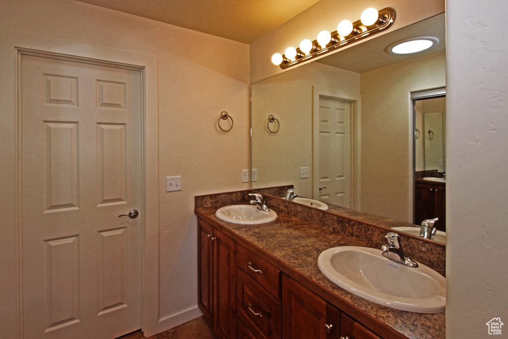 Bathroom featuring double vanity and baseboards