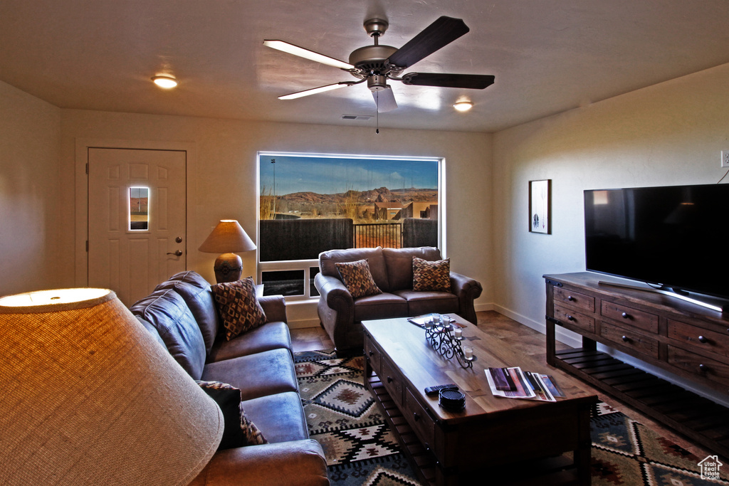 Living area featuring ceiling fan and baseboards