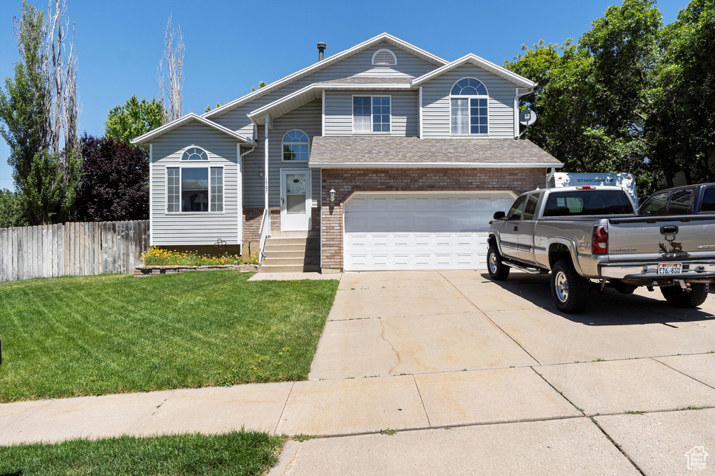 View of front of house featuring concrete driveway, brick siding, and an attached garage