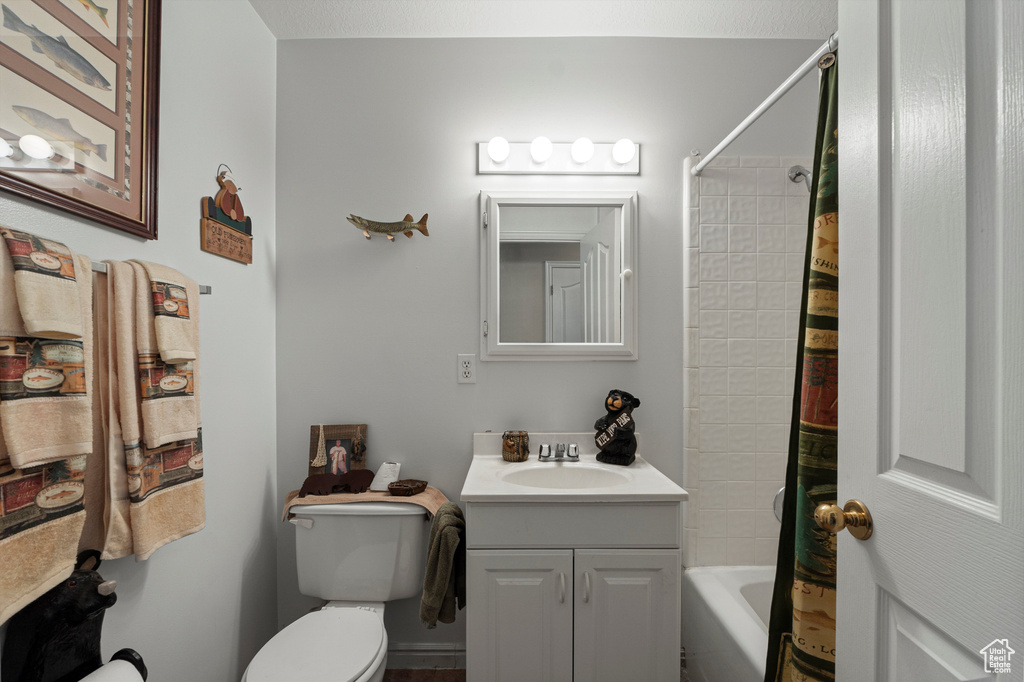 Bathroom with vanity, toilet, and shower / tub combo