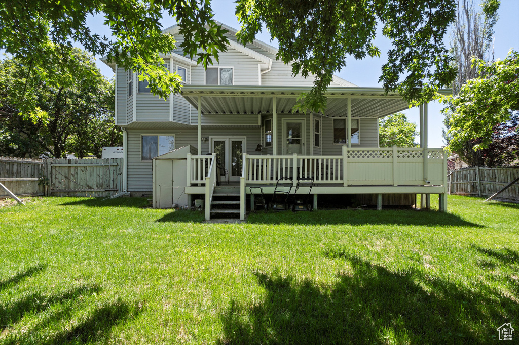 Back of house with a wooden deck, a gate, and french doors