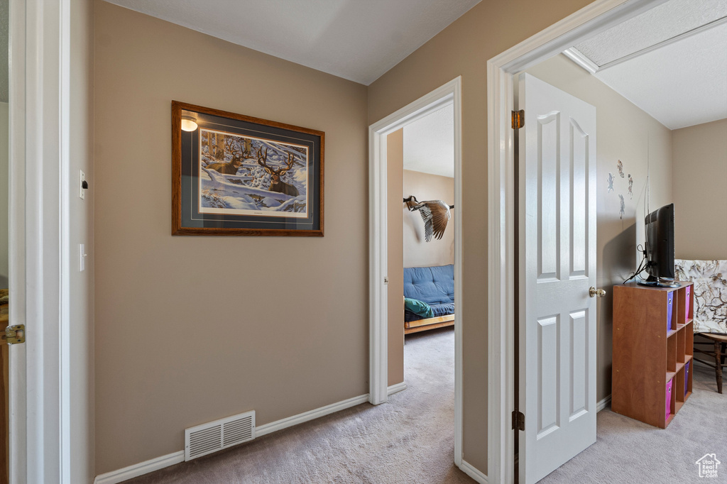 Corridor with carpet flooring and baseboards
