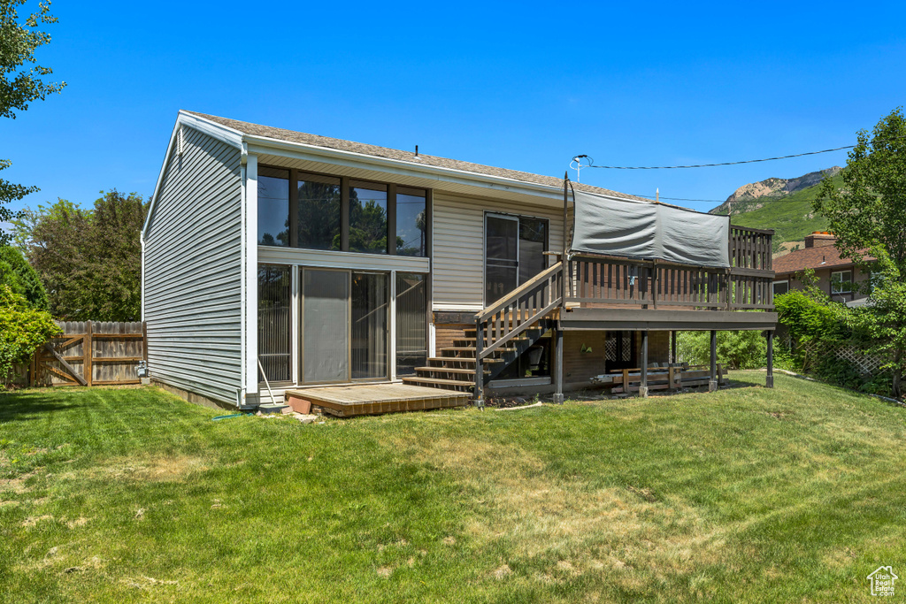 Back of property featuring a deck and stairs