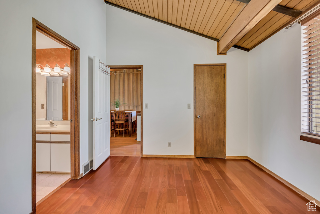 Unfurnished bedroom featuring wood finished floors, wooden ceiling, baseboards, and a sink