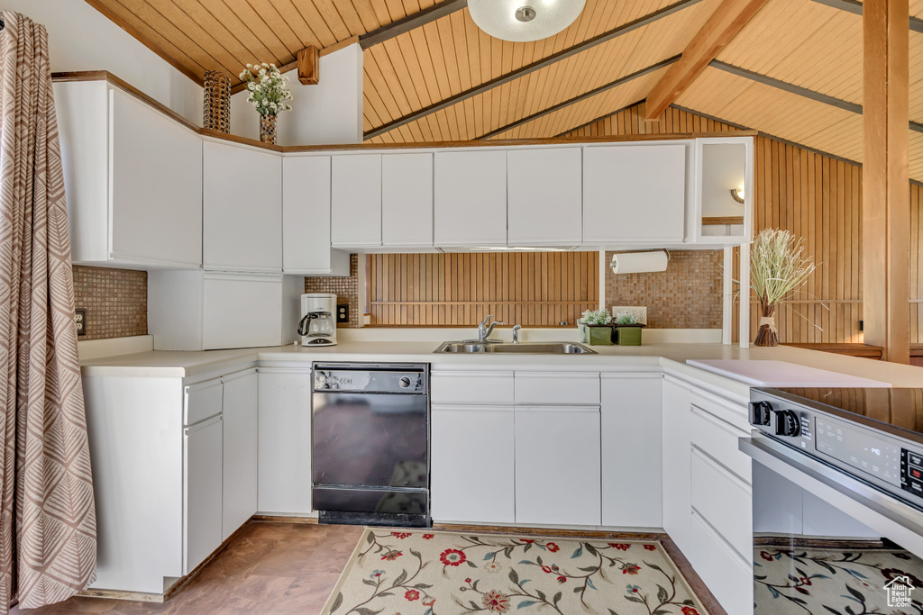 Kitchen featuring dishwasher, a sink, range, white cabinetry, and light countertops