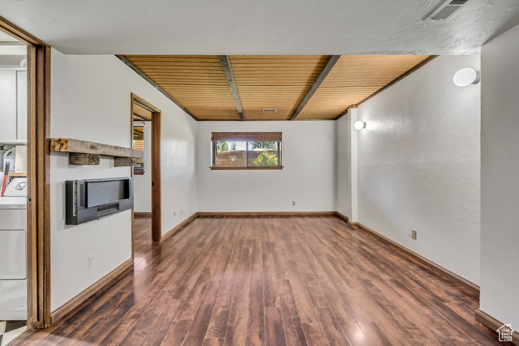 Spare room featuring wood finished floors, washer / clothes dryer, baseboards, and wooden ceiling