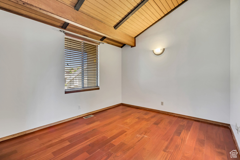 Empty room with baseboards, wood finished floors, and wood ceiling