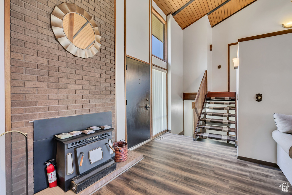 Entrance foyer featuring wood ceiling, high vaulted ceiling, wood finished floors, stairway, and baseboards
