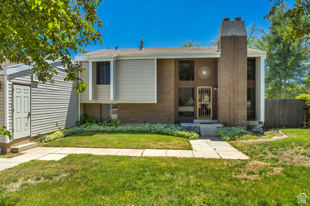 View of front of house with a chimney and brick siding