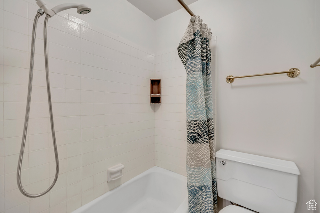 Full bath with shower / bath combo with shower curtain and toilet