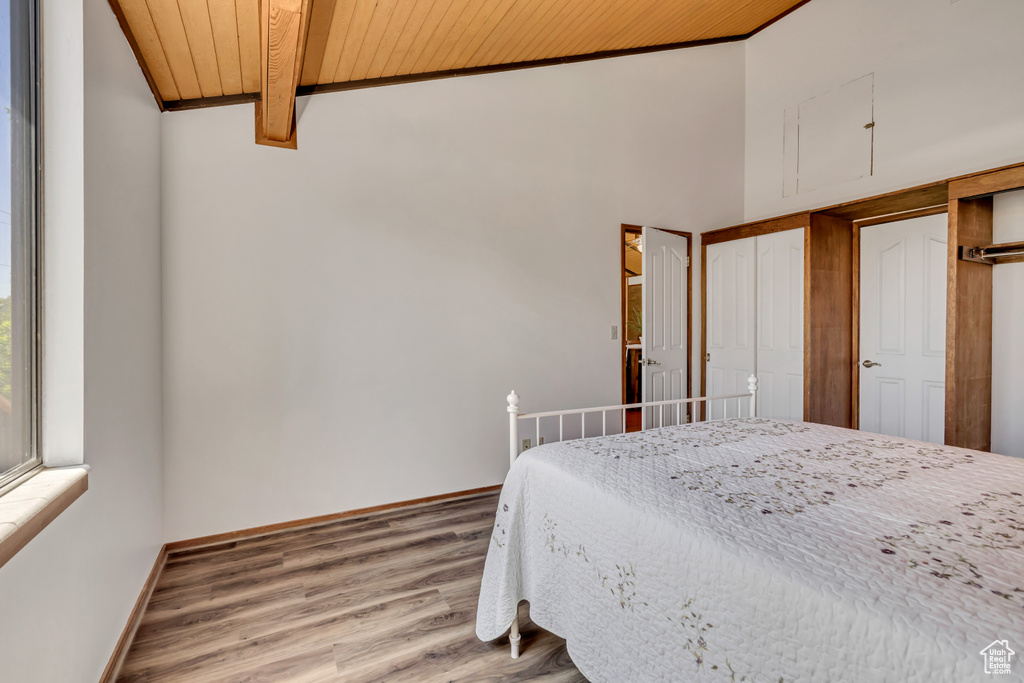 Bedroom with wood ceiling, light wood-type flooring, and baseboards