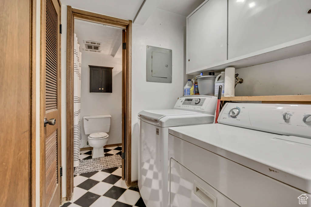 Laundry area featuring independent washer and dryer, electric panel, and light flooring