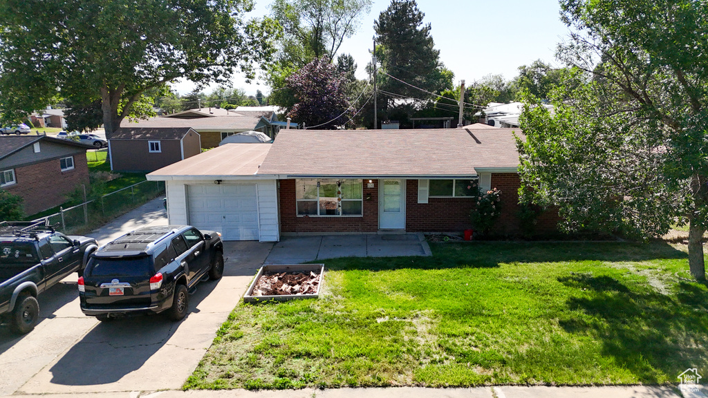Single story home with a garage, brick siding, and concrete driveway