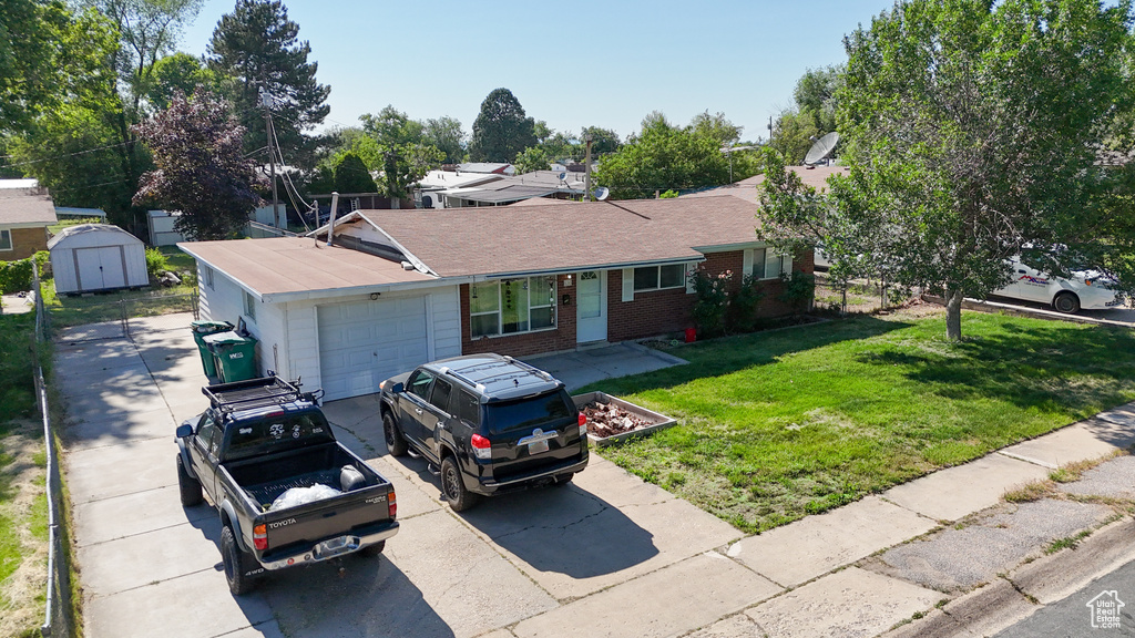 Ranch-style home with a garage, brick siding, concrete driveway, and a front yard