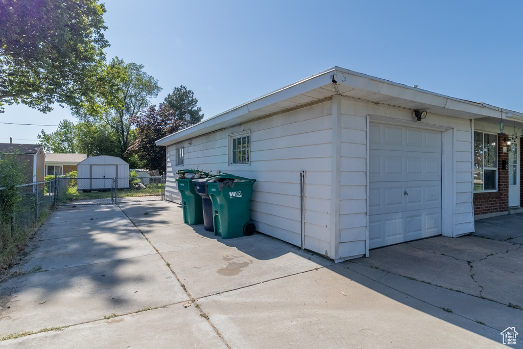 Detached garage featuring a storage unit and concrete driveway