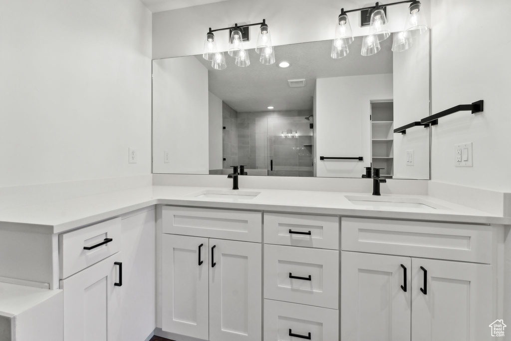 Full bath featuring double vanity and a shower stall