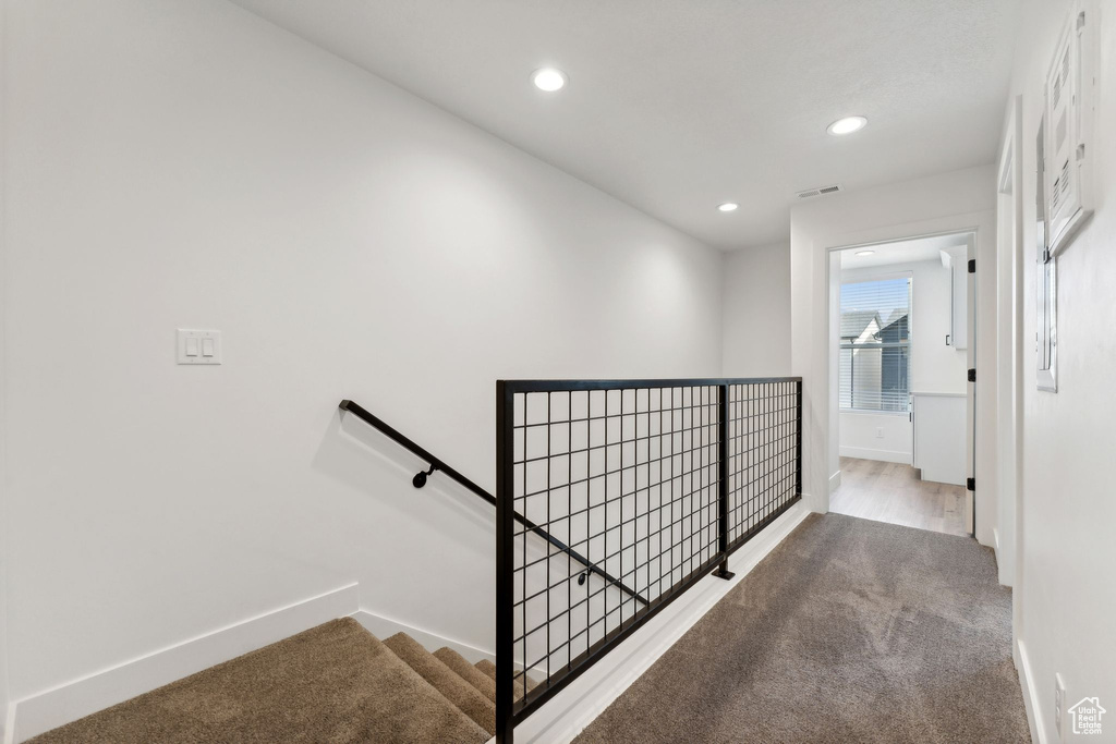 Corridor featuring an upstairs landing, carpet floors, baseboards, and recessed lighting