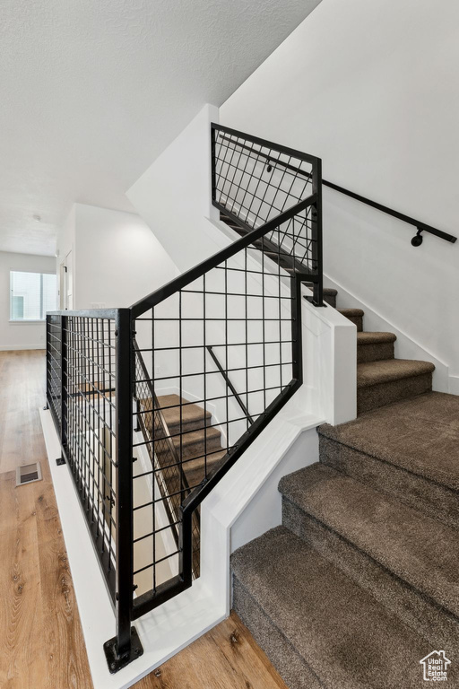 Stairs with wood finished floors and baseboards