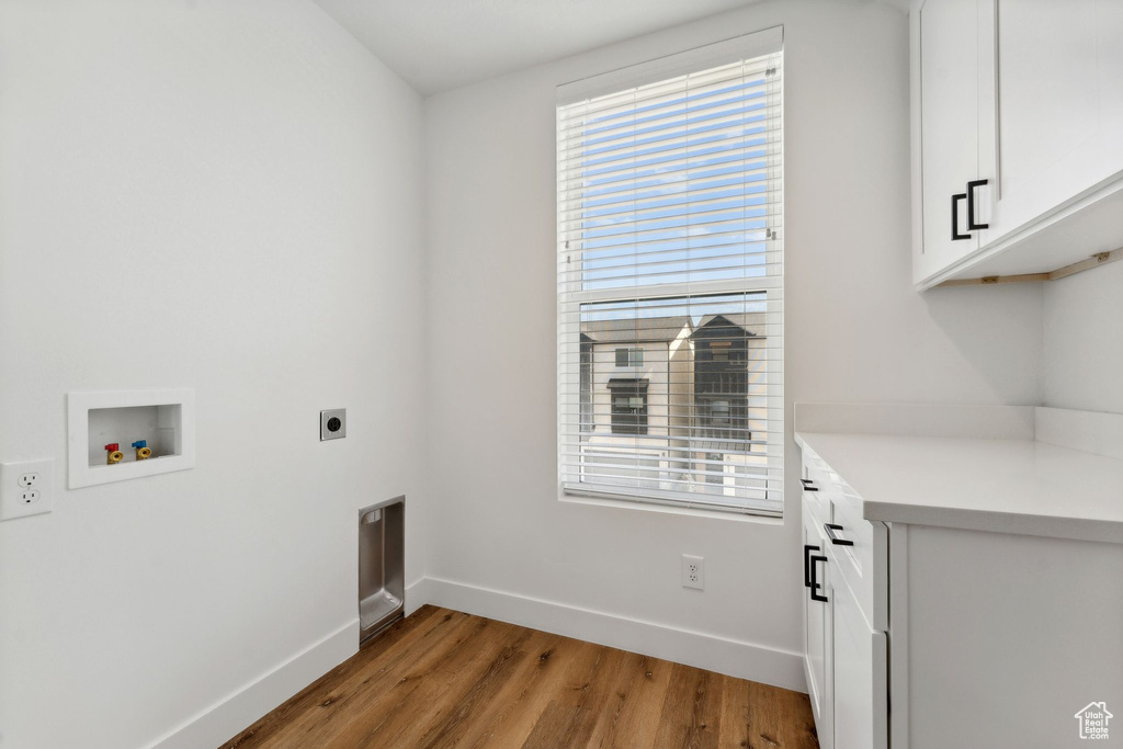 Washroom featuring cabinet space, healthy amount of natural light, hookup for an electric dryer, and baseboards