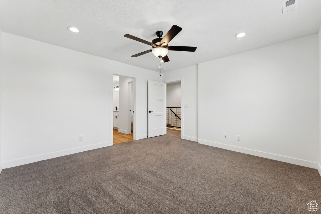 Unfurnished bedroom with light colored carpet, baseboards, recessed lighting, ensuite bath, and ceiling fan