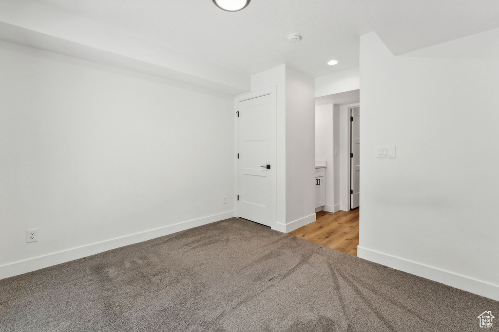 Empty room featuring light colored carpet, baseboards, a smoke detector, and recessed lighting