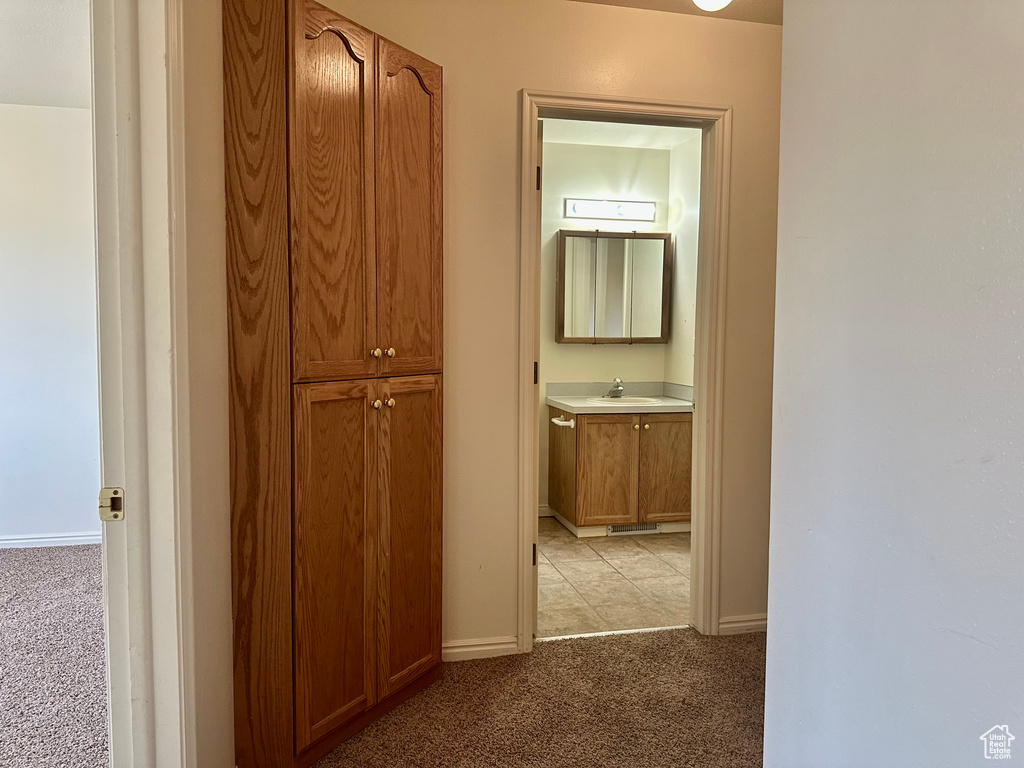 Hall with light colored carpet and baseboards