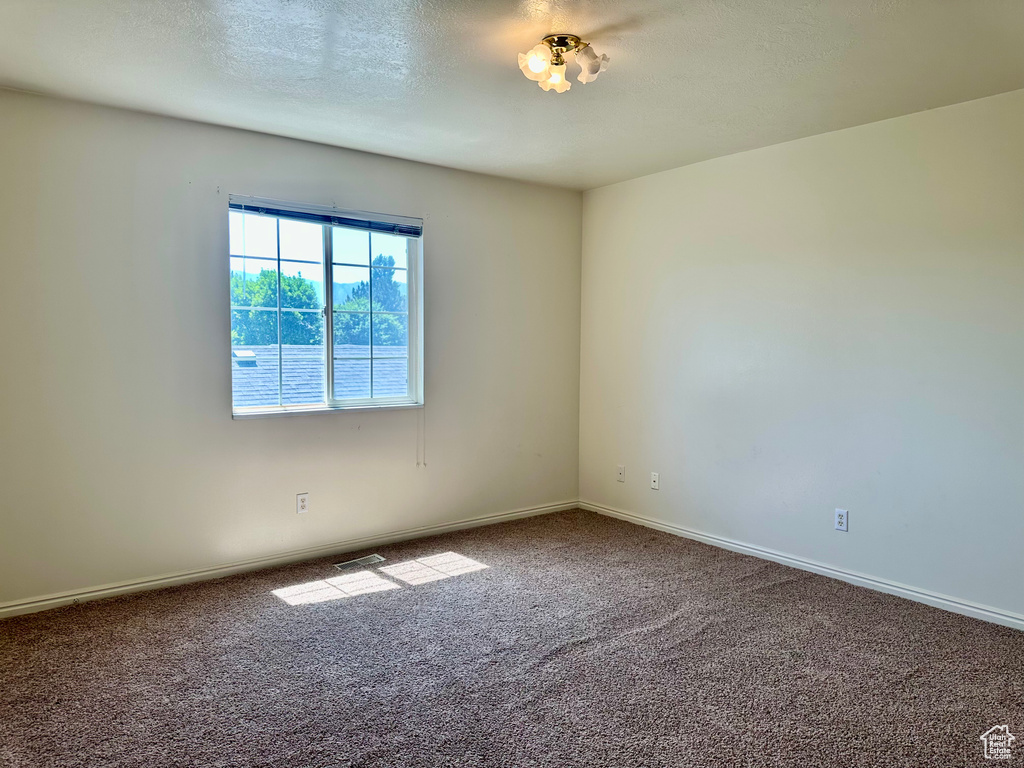 Empty room featuring carpet floors and baseboards