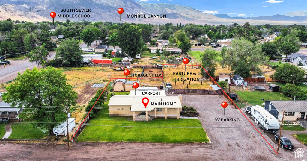 Aerial view of property and surrounding area with a mountain backdrop and property parcel outlined