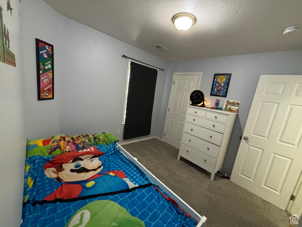 Carpeted bedroom with a textured ceiling