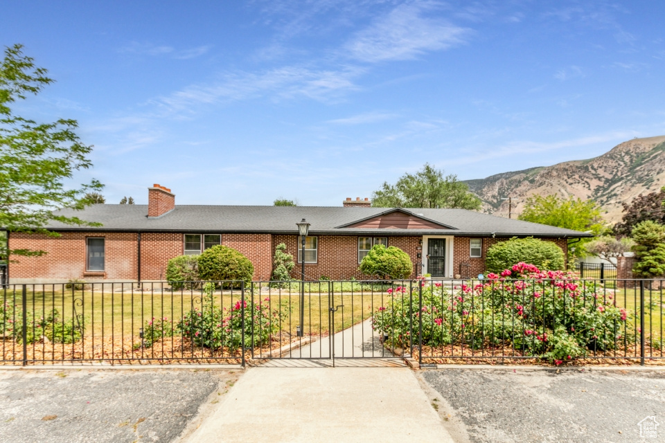 Single story home featuring brick siding, a mountain view, and a chimney
