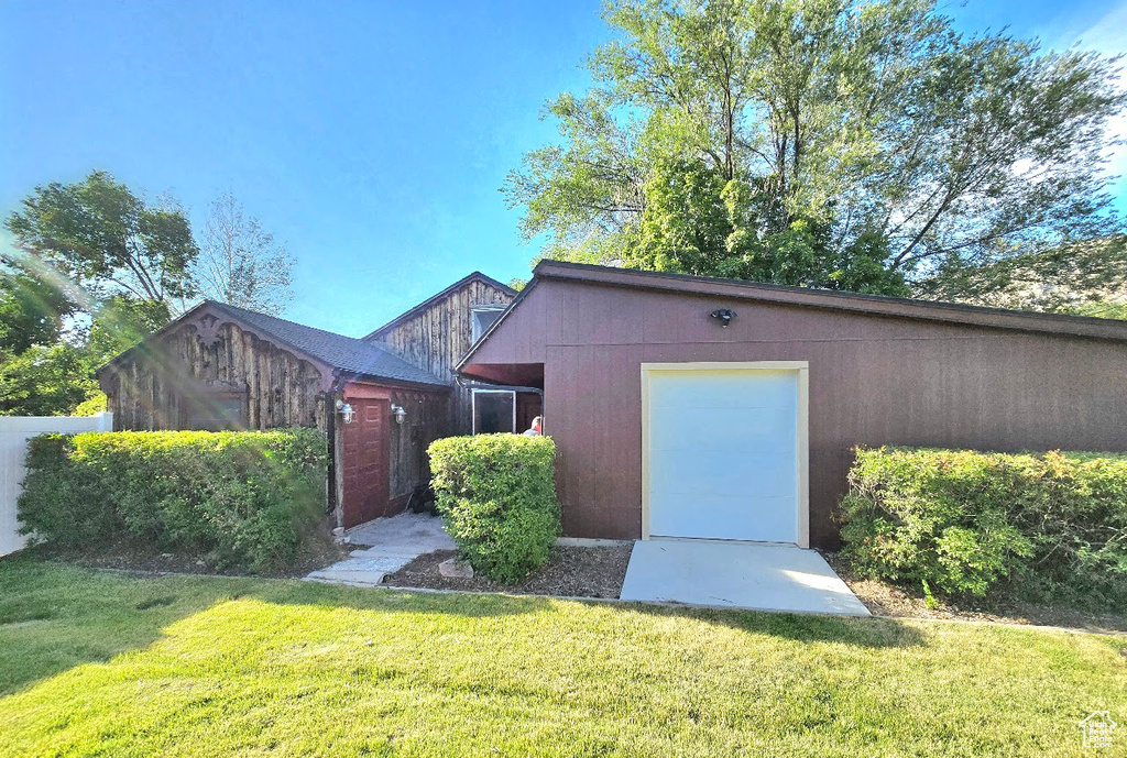 View of front of home with an outbuilding and a front lawn