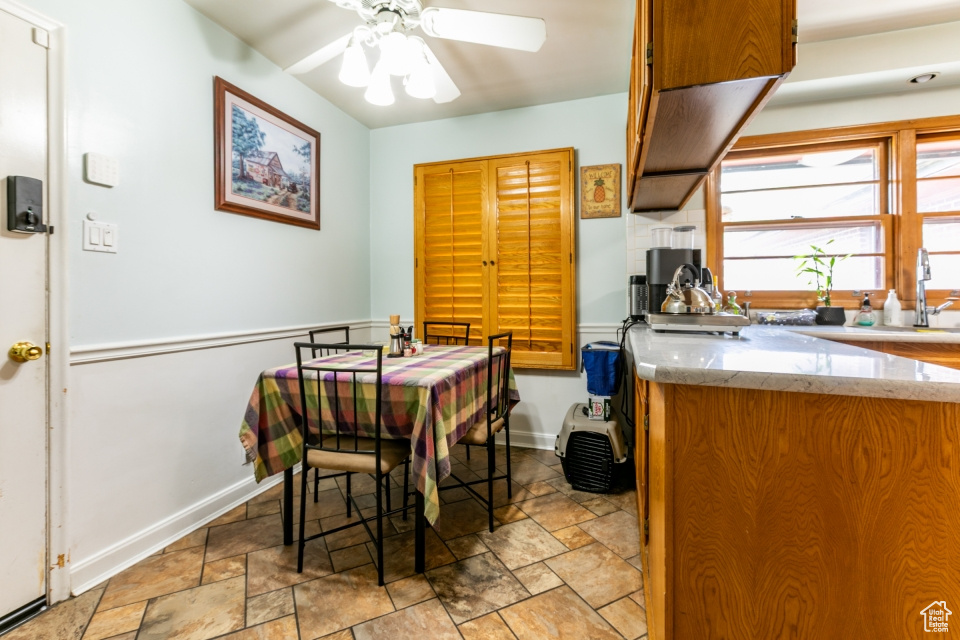 Dining space featuring light stone finish floors and ceiling fan