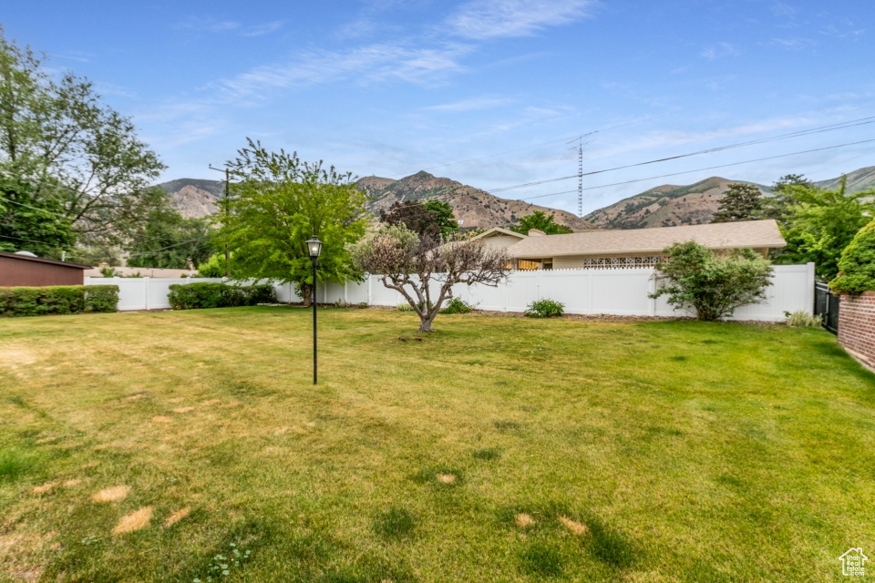 Fenced backyard featuring a mountain view