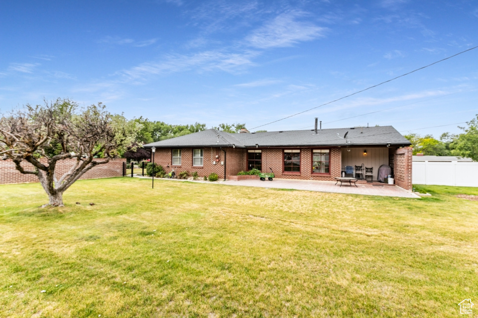 Back of house with a patio area and brick siding