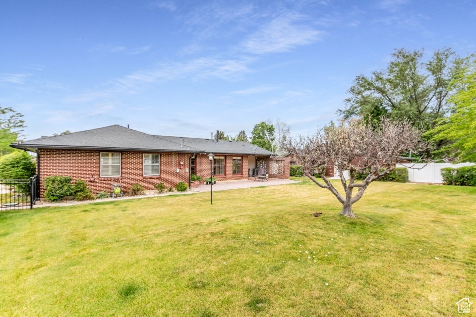 View of front of home with a patio area and brick siding