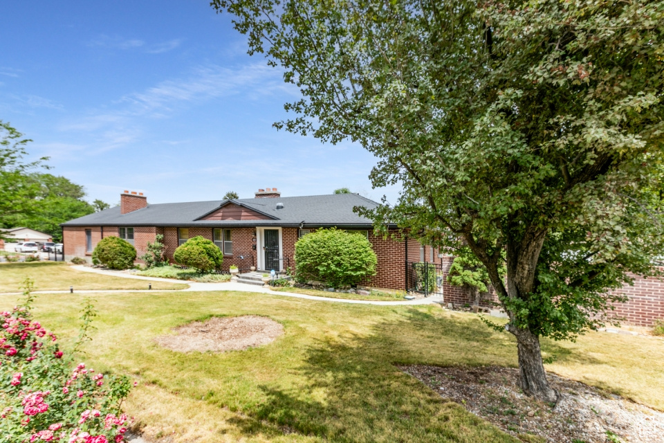 Ranch-style house featuring a front yard and brick siding