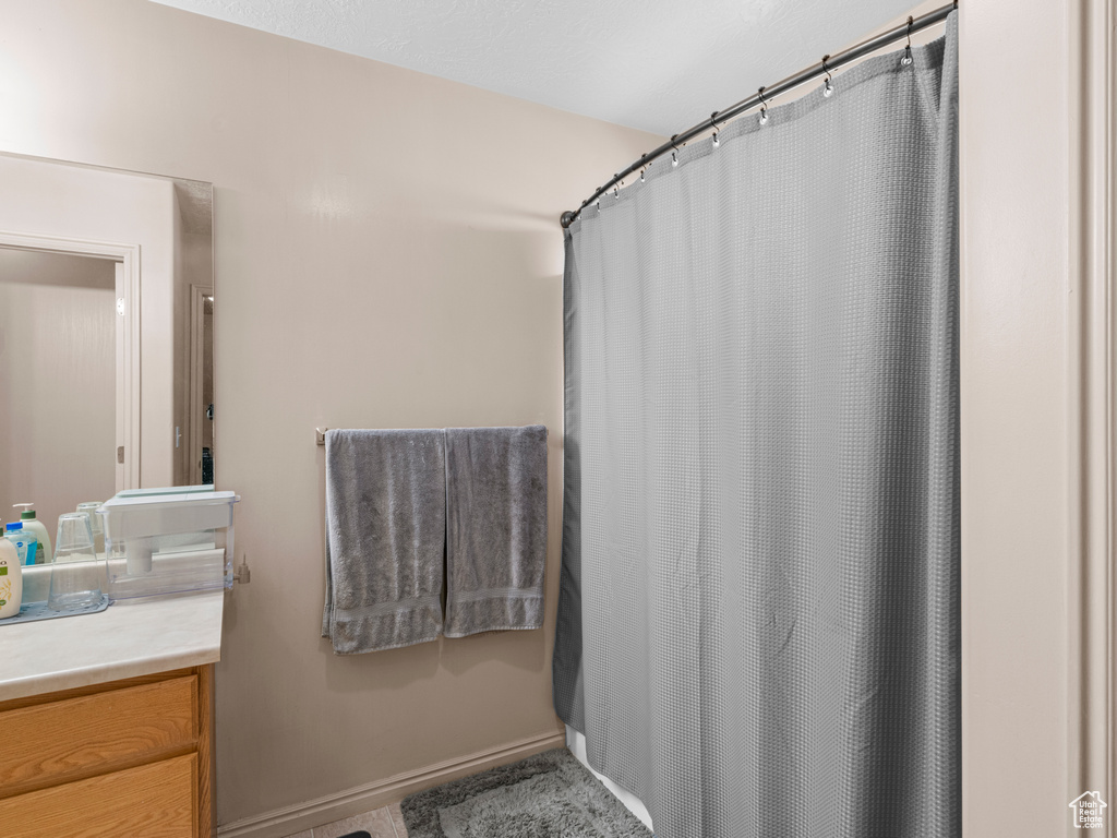 Full bath with vanity and a shower with shower curtain