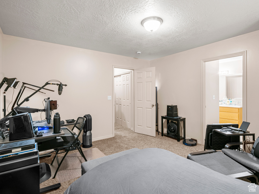 Carpeted bedroom featuring a textured ceiling and baseboards